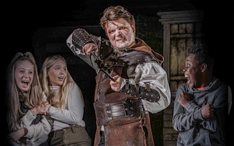 Actor in medieval costume scaring visitors at London Dungeon VIP experience.
