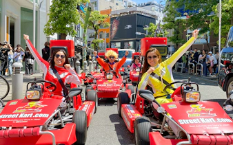 Participants in costumes driving go-karts on a street in Osaka Namba.