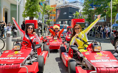 Participants in costumes driving go-karts on a street in Osaka Namba.