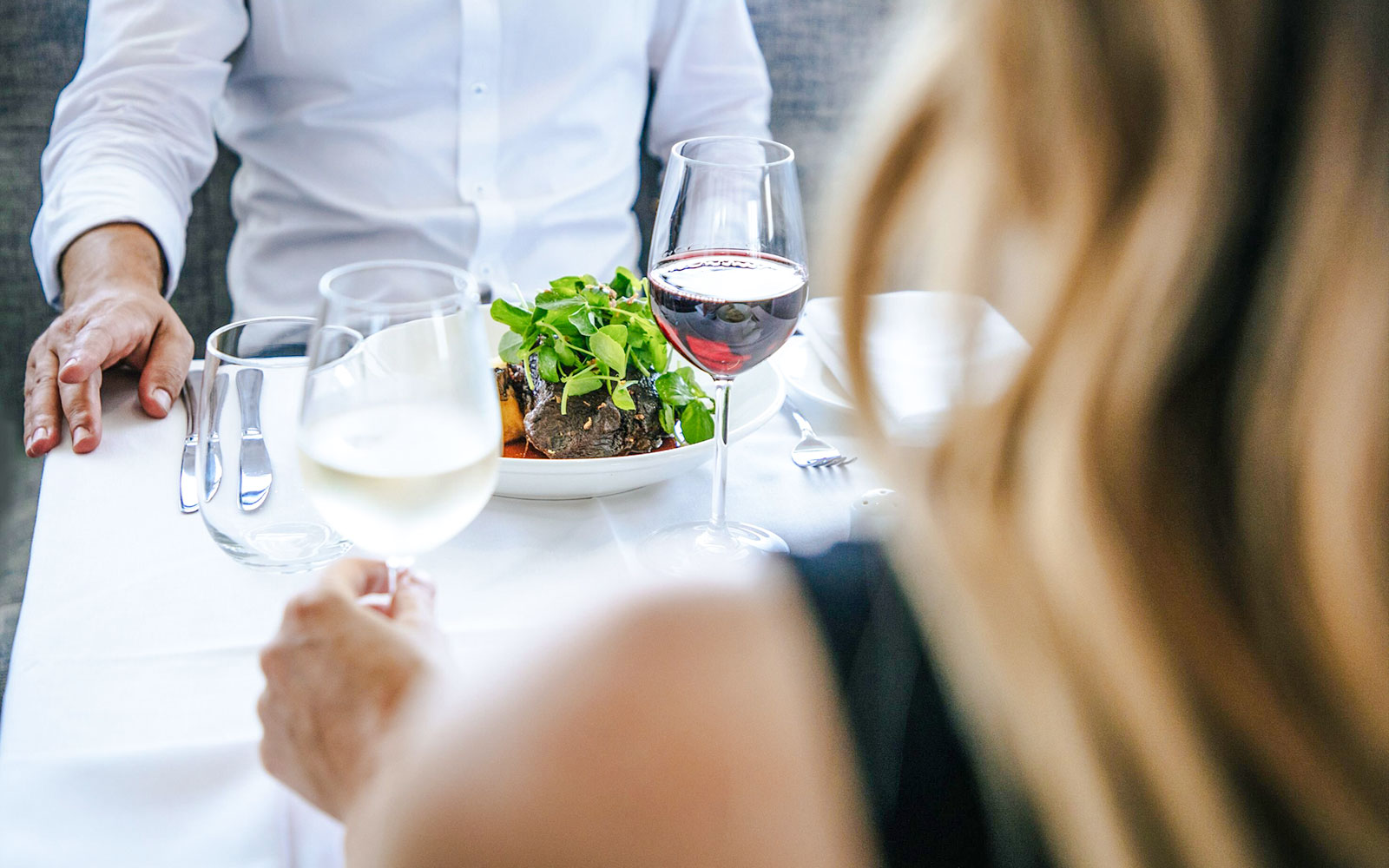 Couple dining with wine on a Sydney cruise.