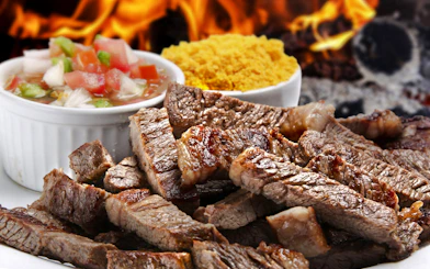 Grilled meat slices with salsa and farofa at a Brazilian steakhouse in Rio de Janeiro.