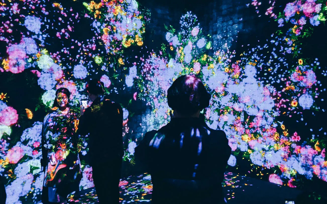 Visitors immersed in digital floral art at teamLab Borderless Museum, Tokyo.