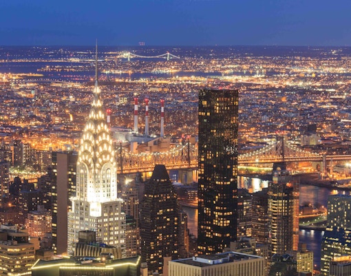 Chrysler Building illuminated at night with New York City skyline in the background.