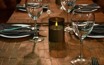 Dining table set with glassware and candle for private Icelandic dining experience.