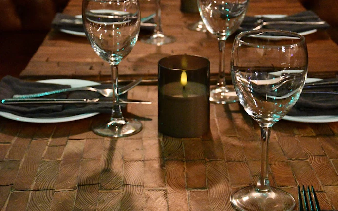 Dining table set with glassware and candle for private Icelandic dining experience.