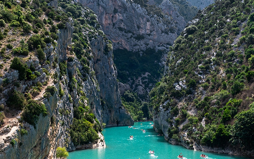 Kayakers navigating turquoise waters between cliffs at Lake of Sainte-Croix, France.