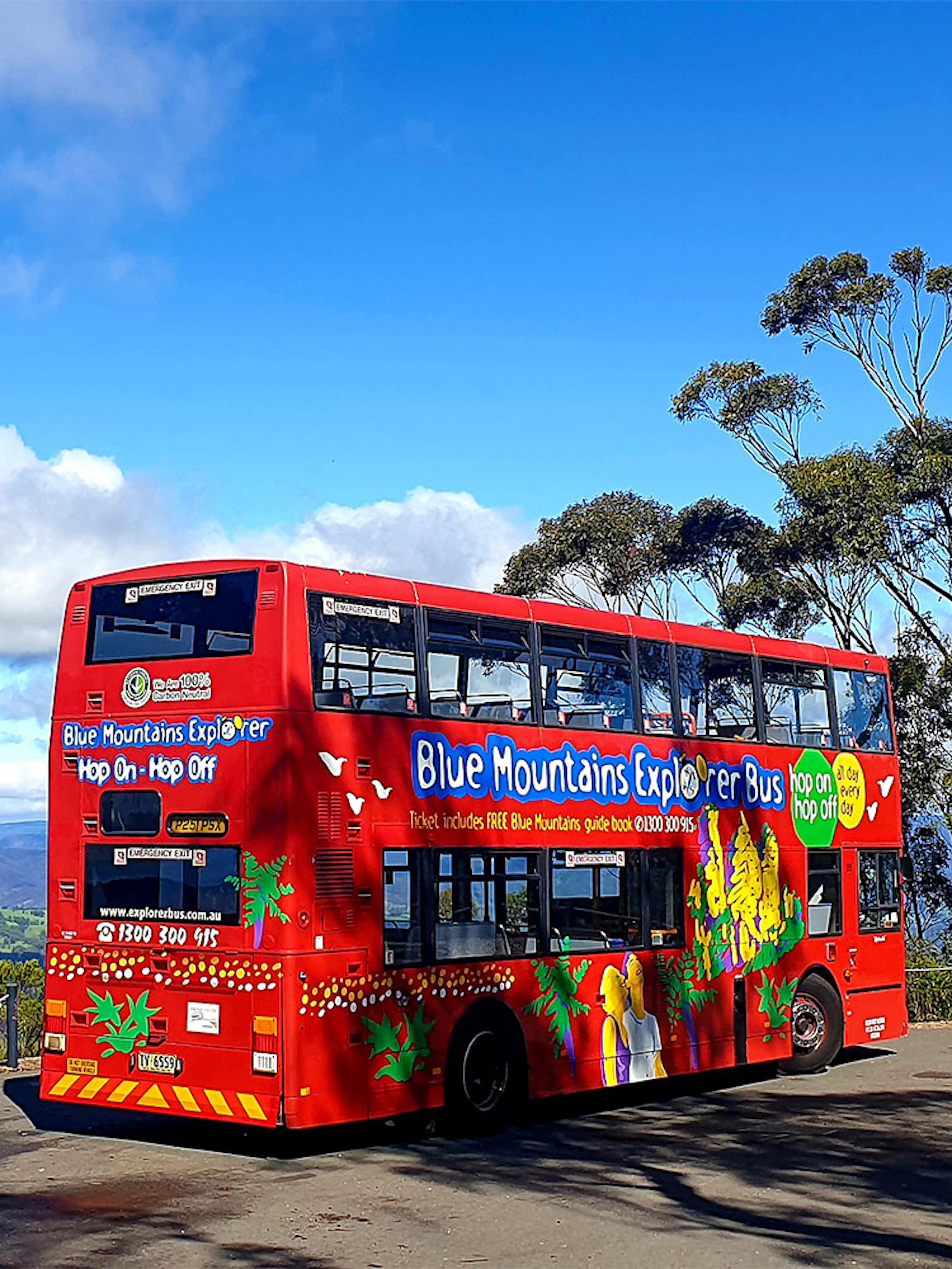 Red double-decker bus on Blue Mountains sightseeing tour with scenic view.