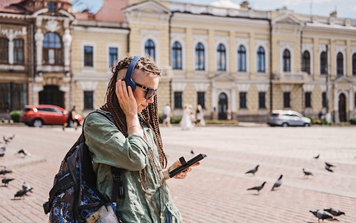 Self-guided audio tour participant in Amsterdam with headphones and tablet.