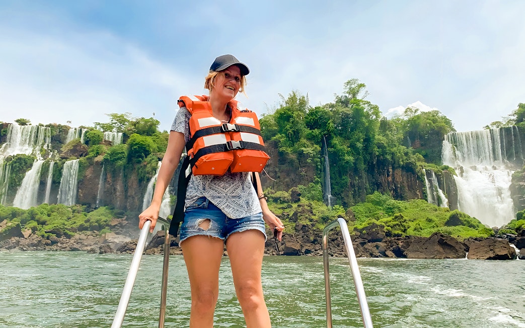 Tourist in life jacket boarding boat at Iguazú Falls, Brazil.