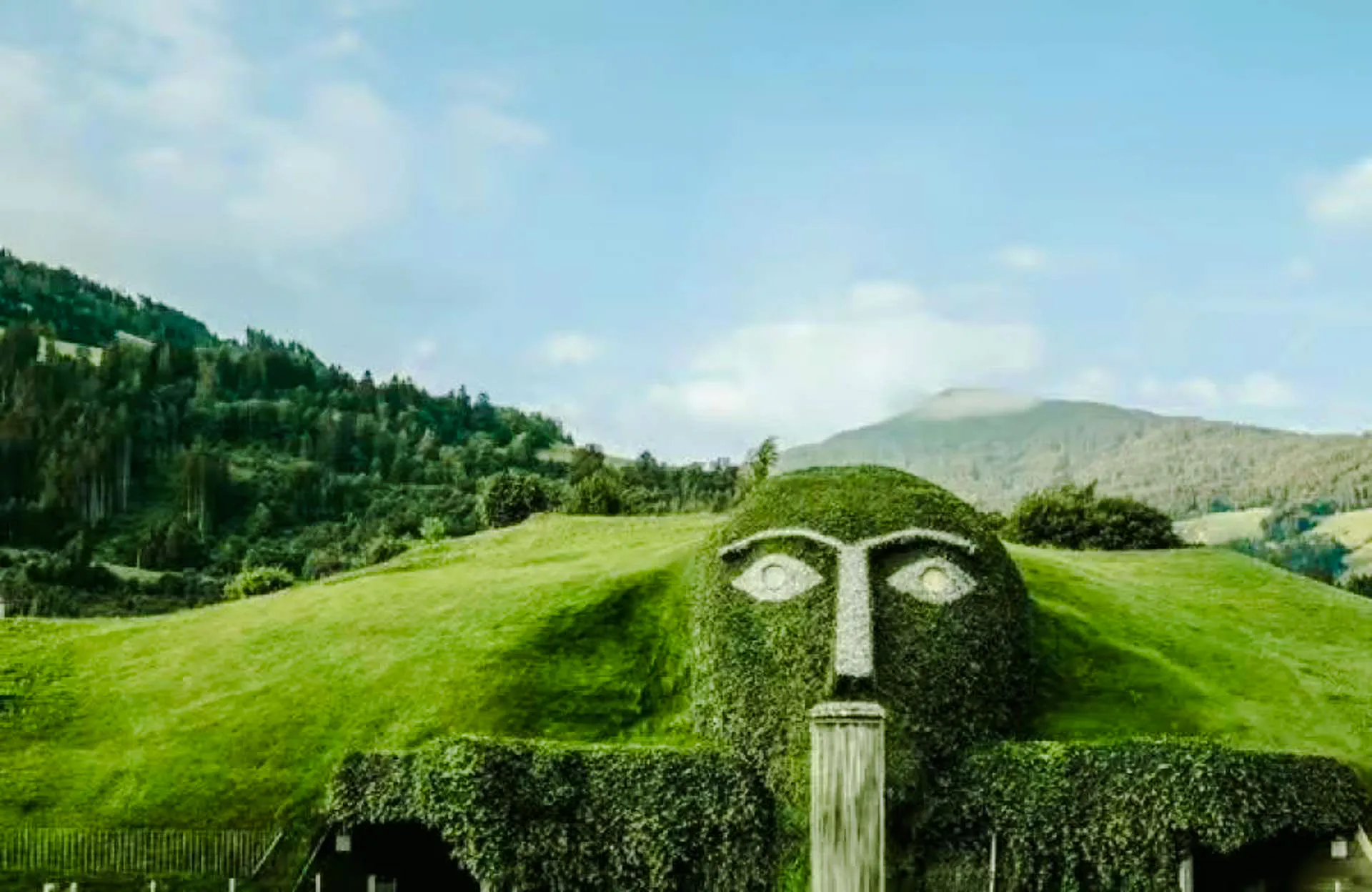 Swarovski Crystal Worlds giant head fountain with mountain backdrop in Innsbruck.