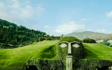 Swarovski Crystal Worlds giant head fountain with mountain backdrop in Innsbruck.