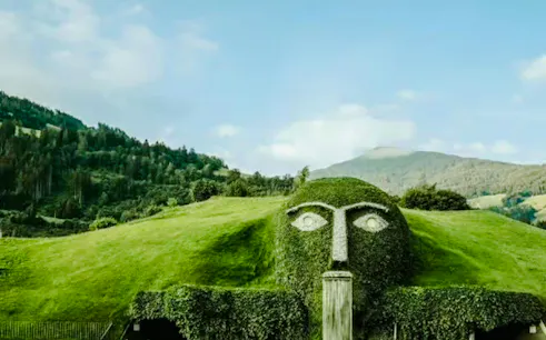 Swarovski Crystal Worlds giant head fountain with mountain backdrop in Innsbruck.