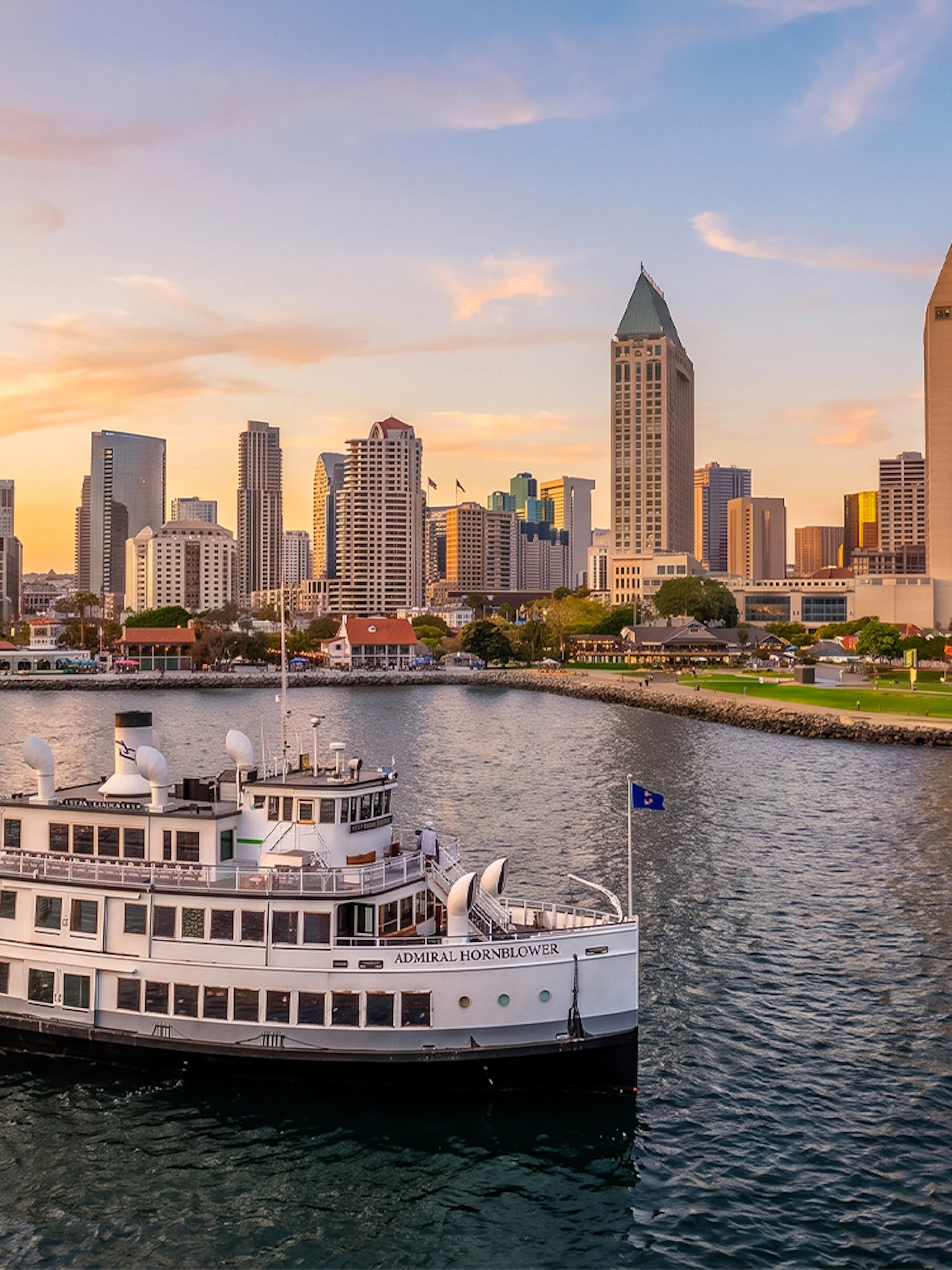 San Diego Premier Cruise sailing by city skyline at sunset.
