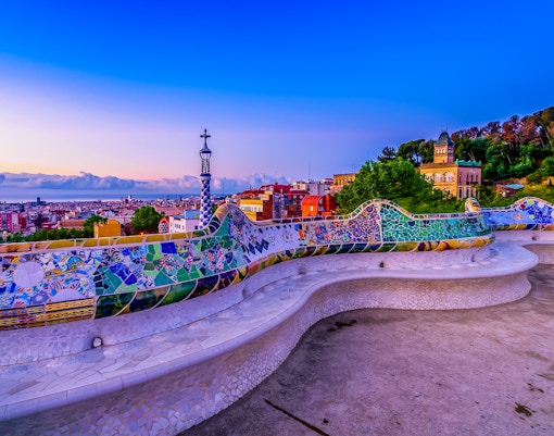 serpentine bench at park guell at sunset