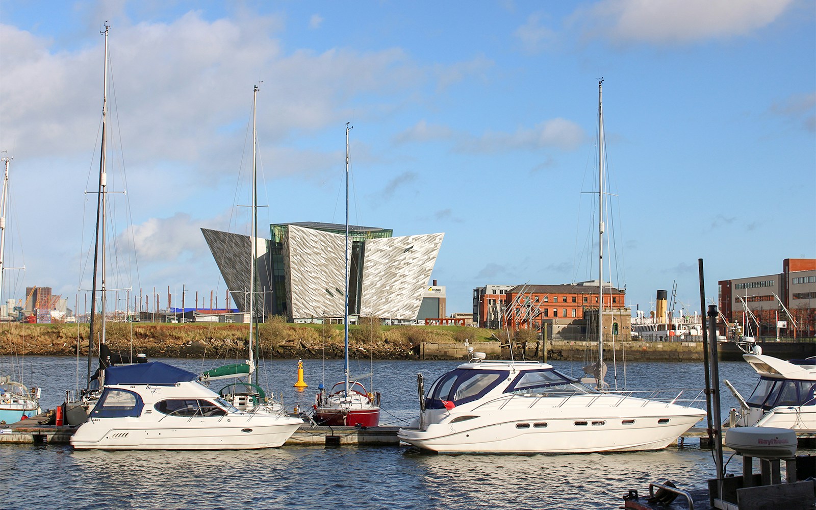 Titanic Belfast Museum with boats docked in the foreground, United Kingdom.