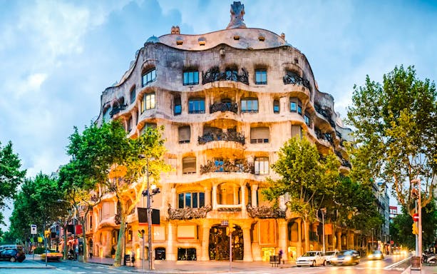 Casa Milà illuminated at dusk during Barcelona night tour.
