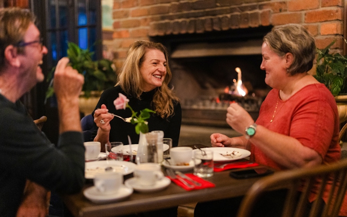 Dining by a cozy fireplace during the Evening Rainforest & Glow Worm Experience.