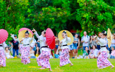 Children performing traditional dance with umbrellas at Lanna Sky Lantern Festival, Chiang Mai.