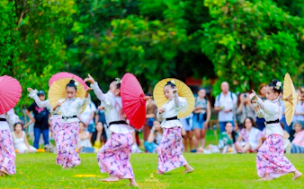 Children performing traditional dance with umbrellas at Lanna Sky Lantern Festival, Chiang Mai.