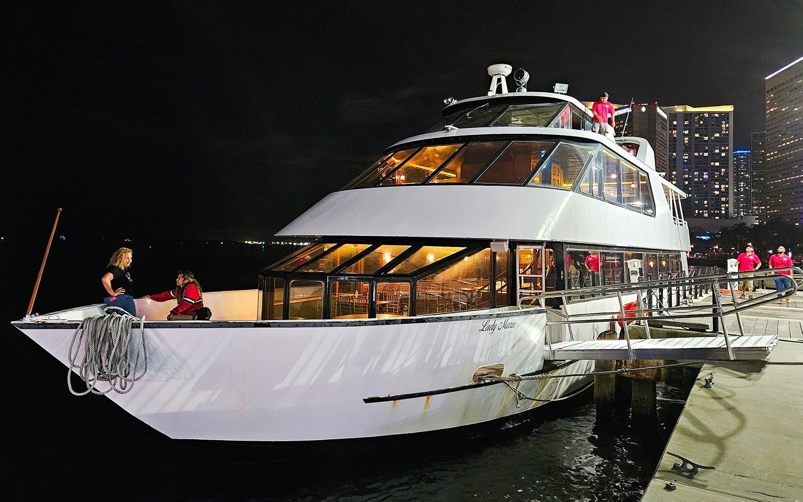 Party boat cruising on Amsterdam's canals with passengers enjoying the view.