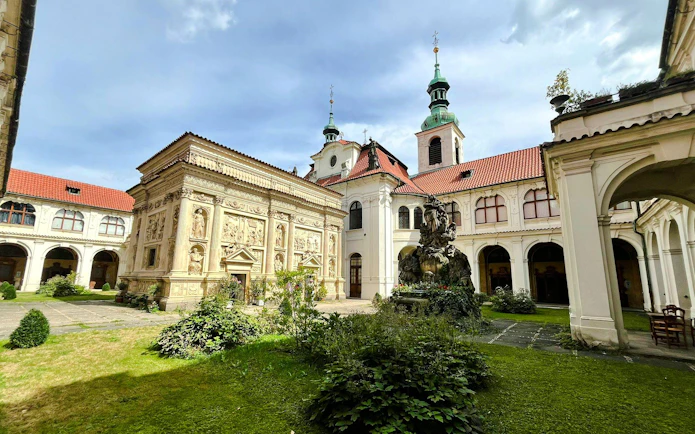 Inner courtyard of the Loreto complex in Prague with ornate architecture and a central fountain.