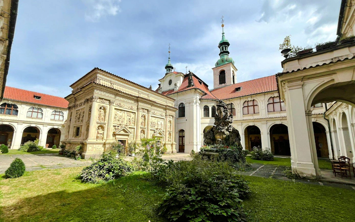 Inner courtyard of the Loreto complex in Prague with ornate architecture and a central fountain.