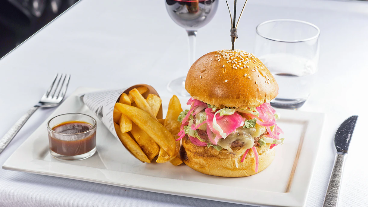 Burger and fries served at Le Bistro Parisien with a glass of red wine.