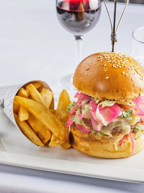 Burger and fries served at Le Bistro Parisien with a glass of red wine.