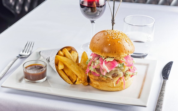 Burger and fries served at Le Bistro Parisien with a glass of red wine.