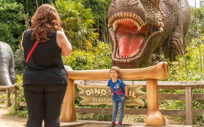 Child posing in front of dinosaur exhibit at Drayton Manor.