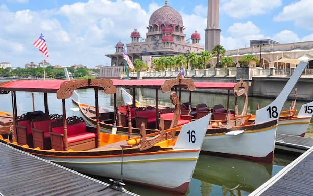 Boats docked at Tasik Putrajaya with Putra Mosque in the background.