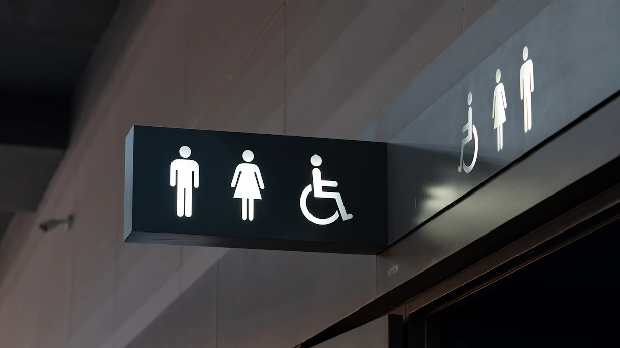 Restroom signs at Reichstag Berlin indicating male, female, and accessible facilities.