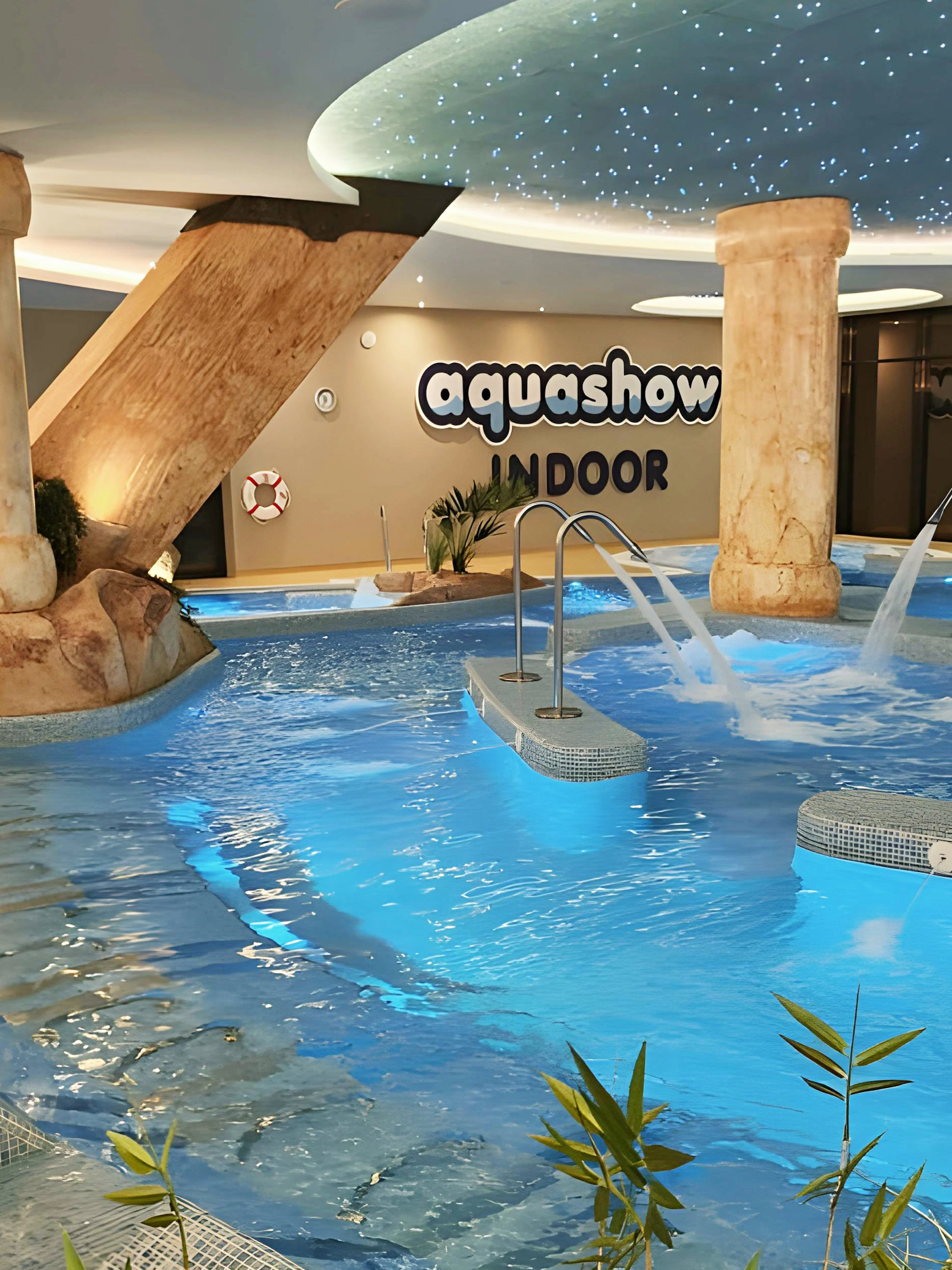 Indoor pool area with water jets and stone pillars at Aquashow Indoor Park.