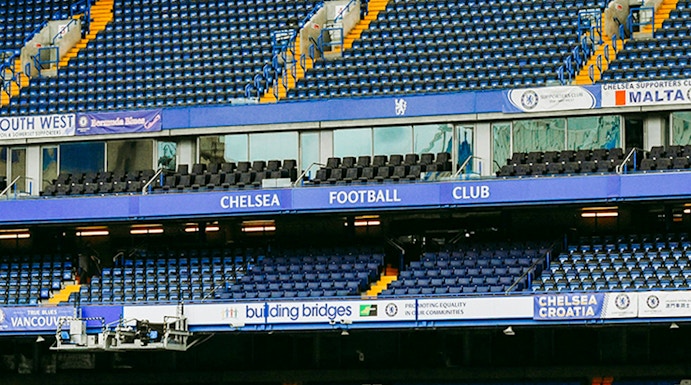 Chelsea FC Stadium seating area with blue and white seats and club signage.