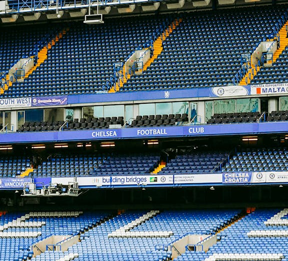 Chelsea FC Stadium seating area with blue and white seats and club signage.