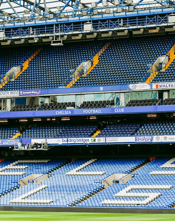 Chelsea FC Stadium seating area with blue and white seats and club signage.