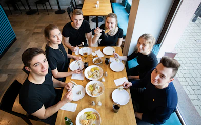 Group enjoying Polish dumplings at a cooking class in a cozy setting.