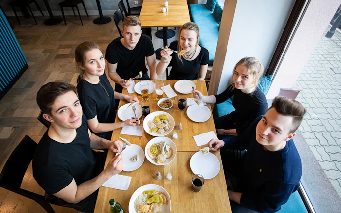 Group enjoying Polish dumplings at a cooking class in a cozy setting.