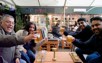 Group enjoying drinks at a cozy bar in Reykjavík during a private bar crawl with a local guide.