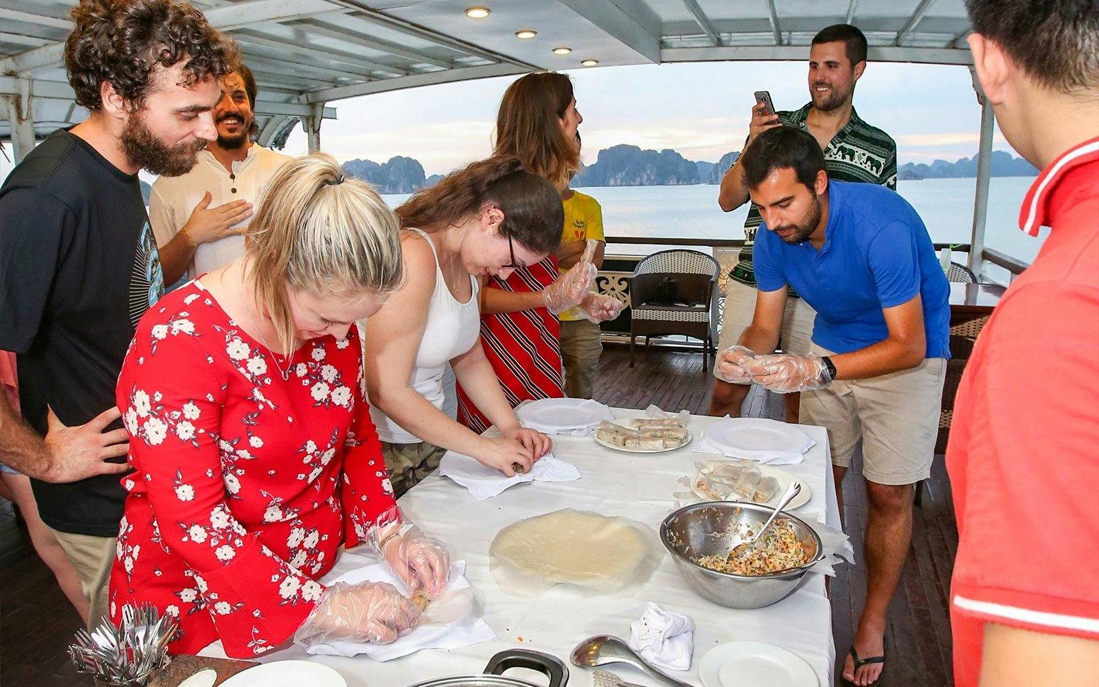 Guests making spring rolls during Halong Bay 2D1N 3 Star Cruise cooking class.
