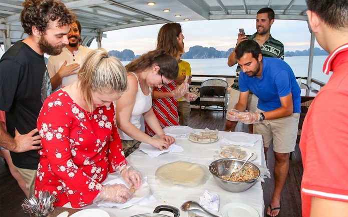 Guests making spring rolls during Halong Bay 2D1N 3 Star Cruise cooking class.
