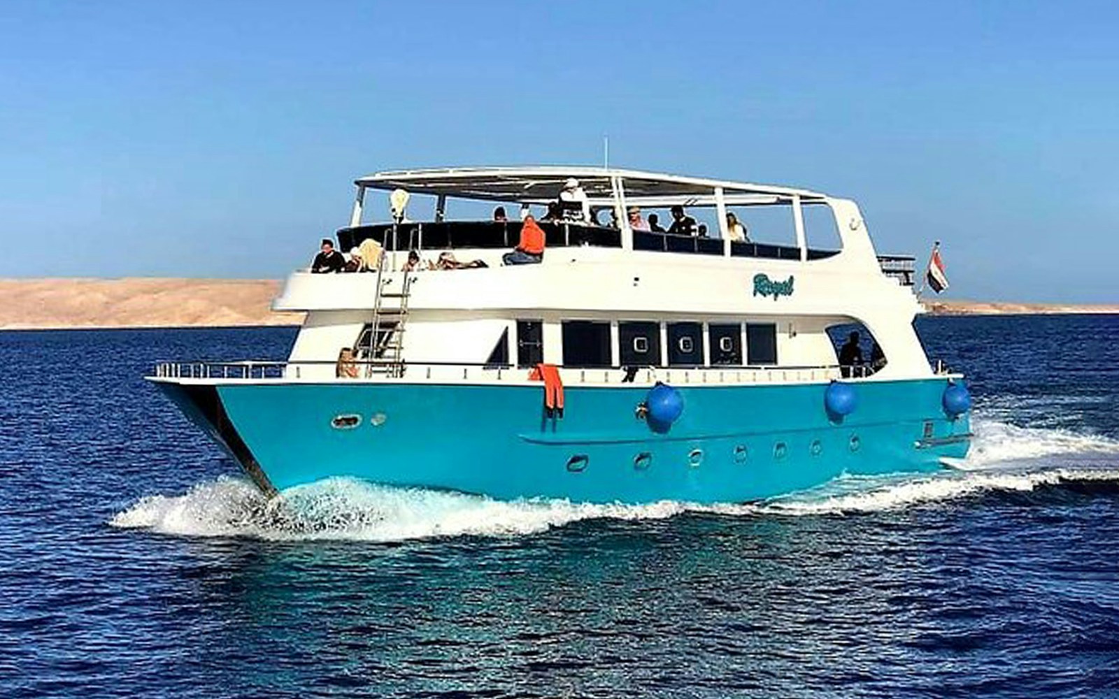 Boat cruising in Hurghada for a full-day tour with snorkeling and lunch.