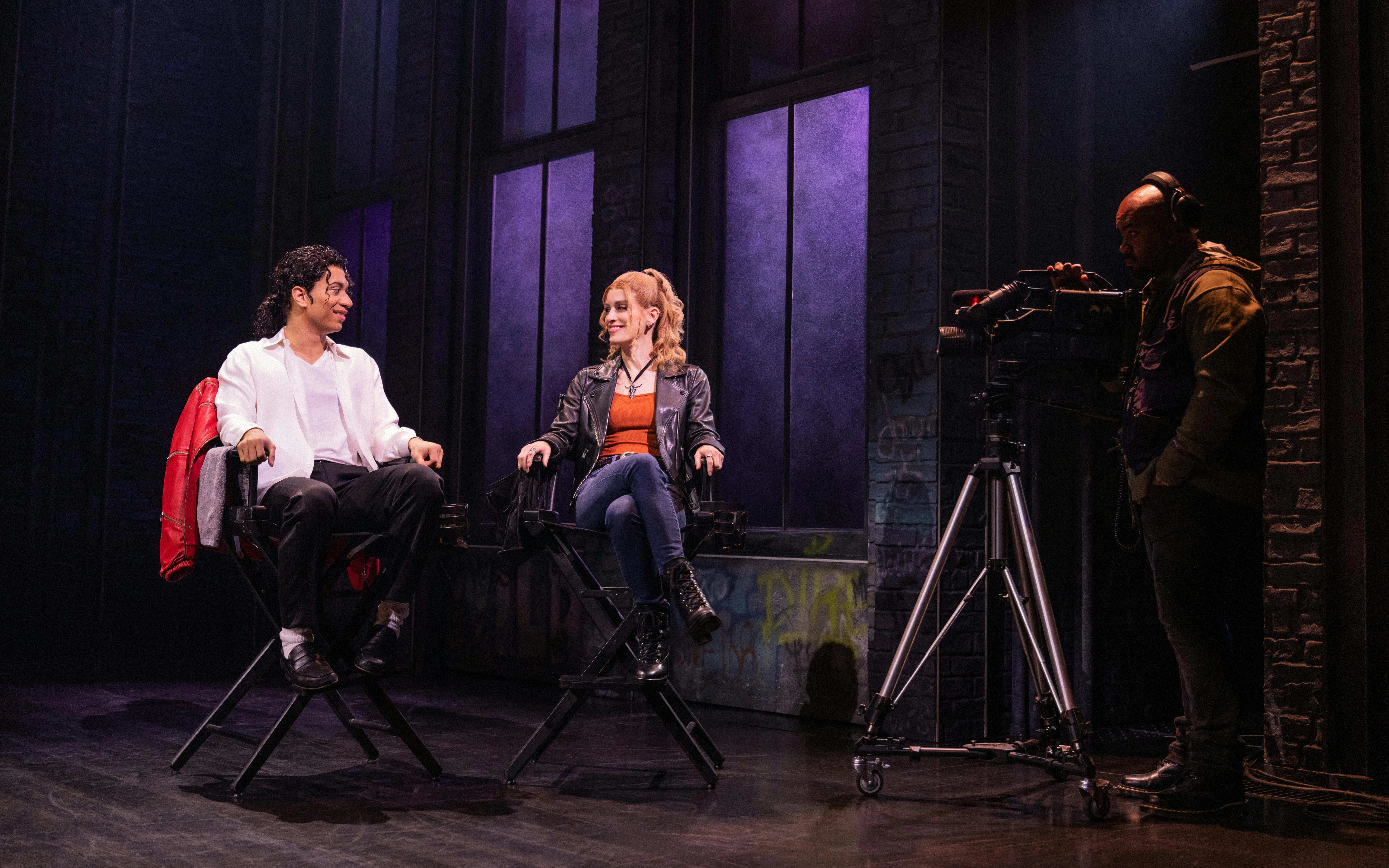 Actors on stage during MJ the Musical on Broadway, with a cameraman filming.
