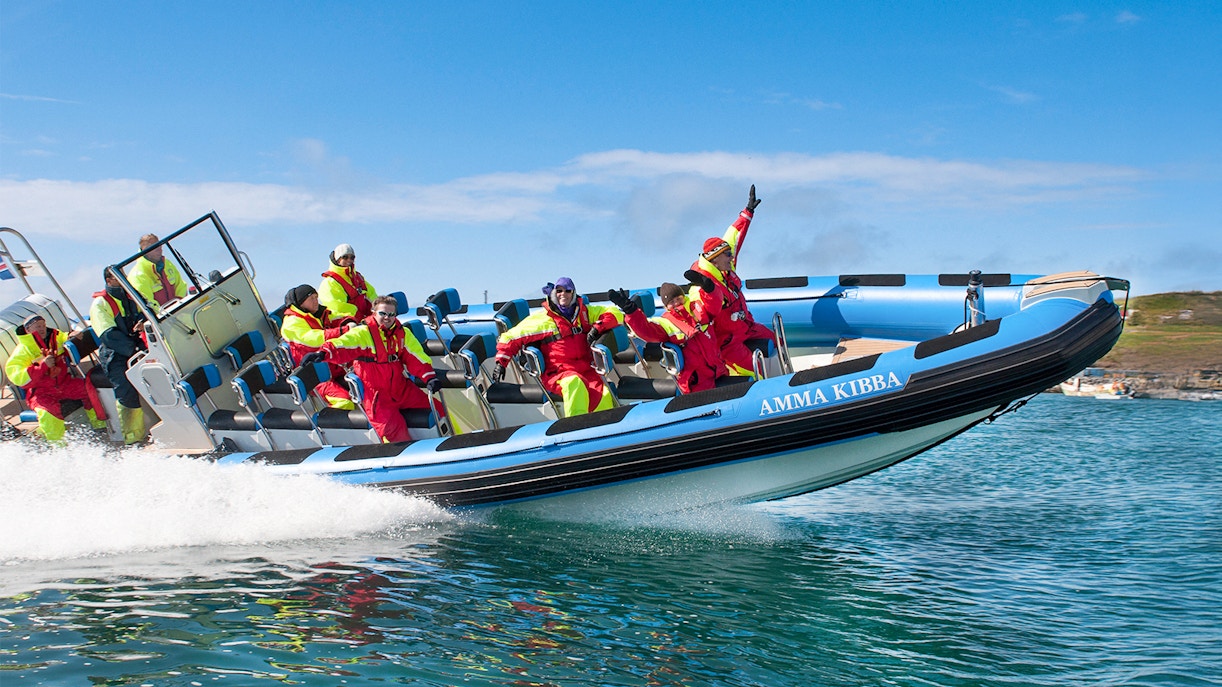 RIB speedboat with passengers on Husavik waters during whale and puffin tour, Iceland.