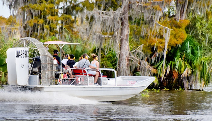 Airboat with tourists exploring swamp in New Orleans.