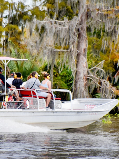 Airboat with tourists exploring swamp in New Orleans.