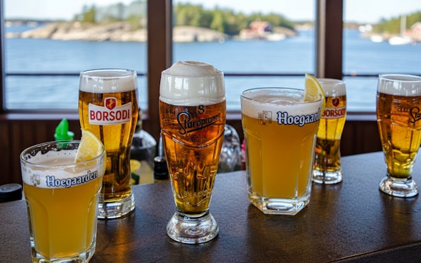 Glasses of beer on a cruise with Stockholm archipelago view.