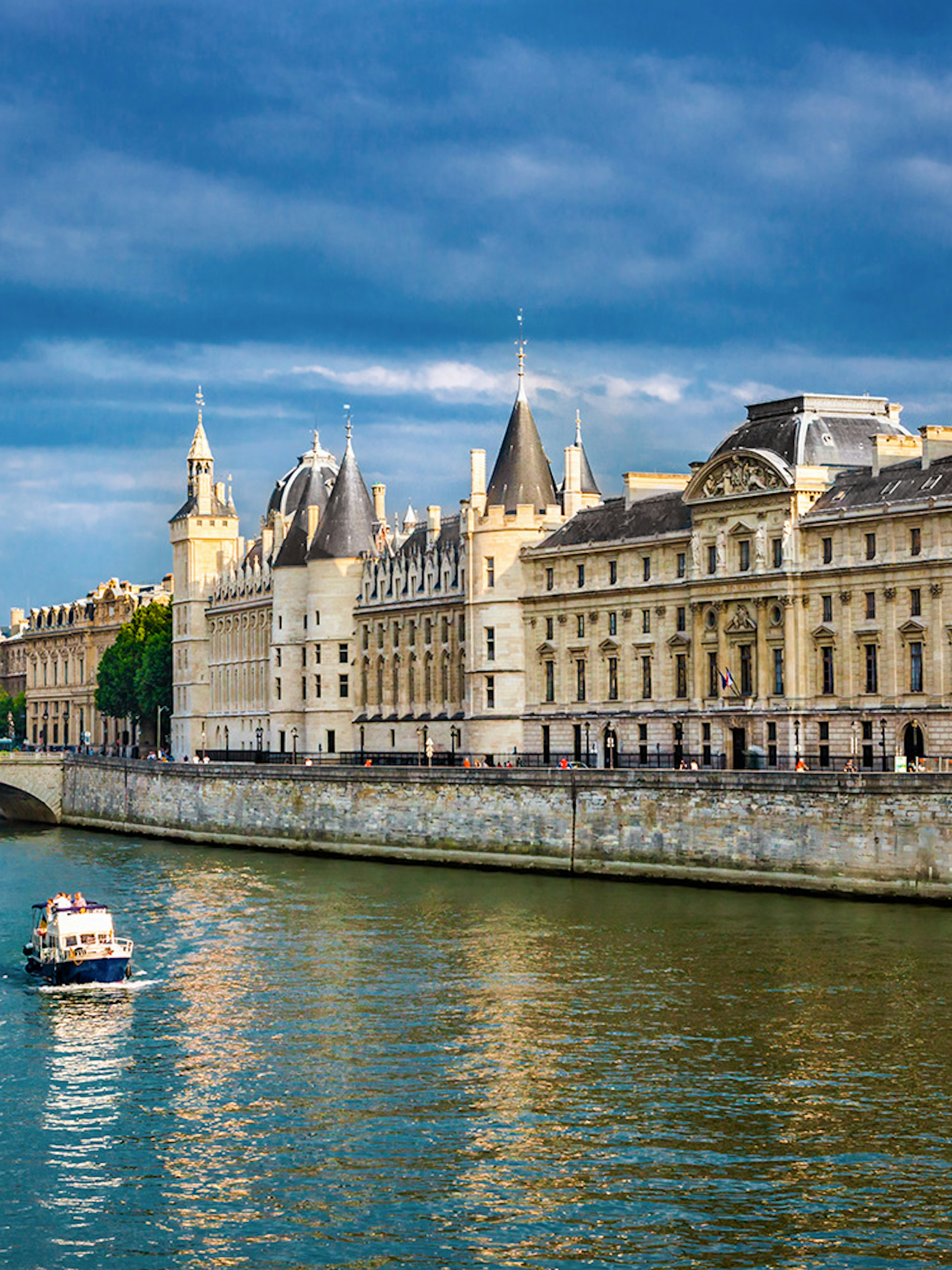 Conciergerie in Paris with boats on the Seine River.