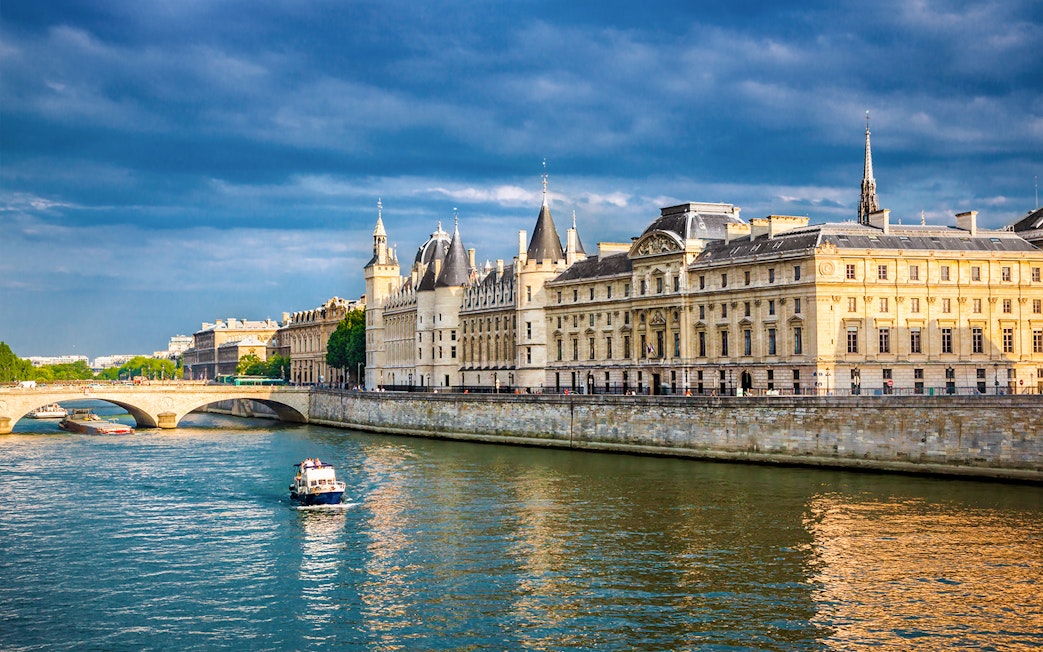 Conciergerie in Paris with boats on the Seine River.
