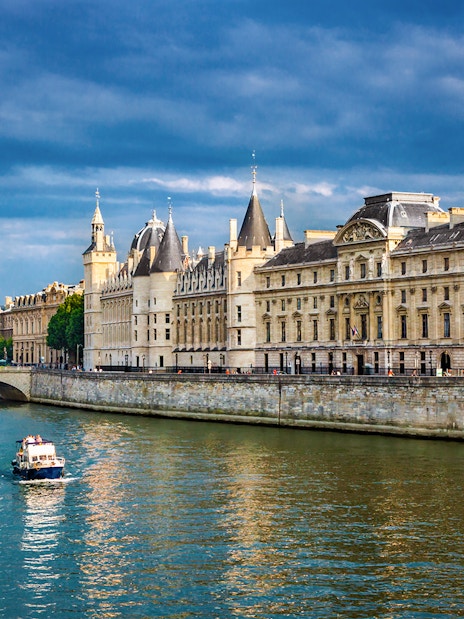 Conciergerie in Paris with boats on the Seine River.